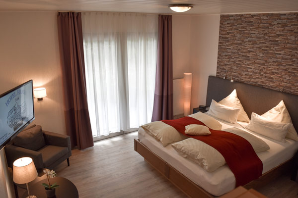 Barrierefreies Gästezimmer - Doppelbett mit Einzelmatrazen je 90x200cm und manuell verstellbarem Kopfteil, Sitzgruppe (oder 3.Bett), Flachbild-TV, Schreibtisch mit Minibar