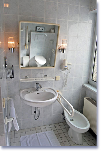 Barrierefreies Gästezimmer - Badzeimmer - unterfahrbares Waschbecken mit Kippspiegel, Haltgriffen